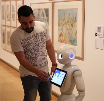 Leandro Guedes interacting with a Pepper robot at the QUT Art Museum